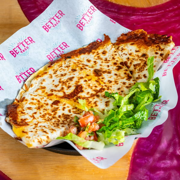 A cheesy quesadilla from The Better Taco, served with fresh lettuce and pico de gallo.