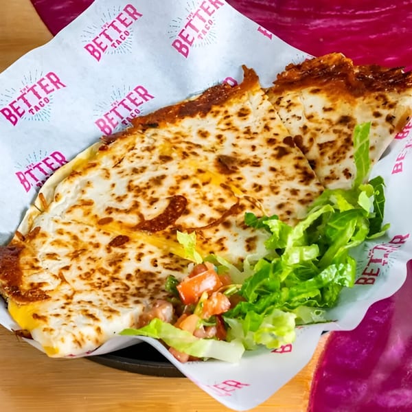 A cheesy quesadilla from The Better Taco, served with fresh lettuce and pico de gallo.