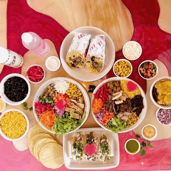 An overhead view of a vibrant Mexican feast with burritos, tacos, and colorful bowls.
